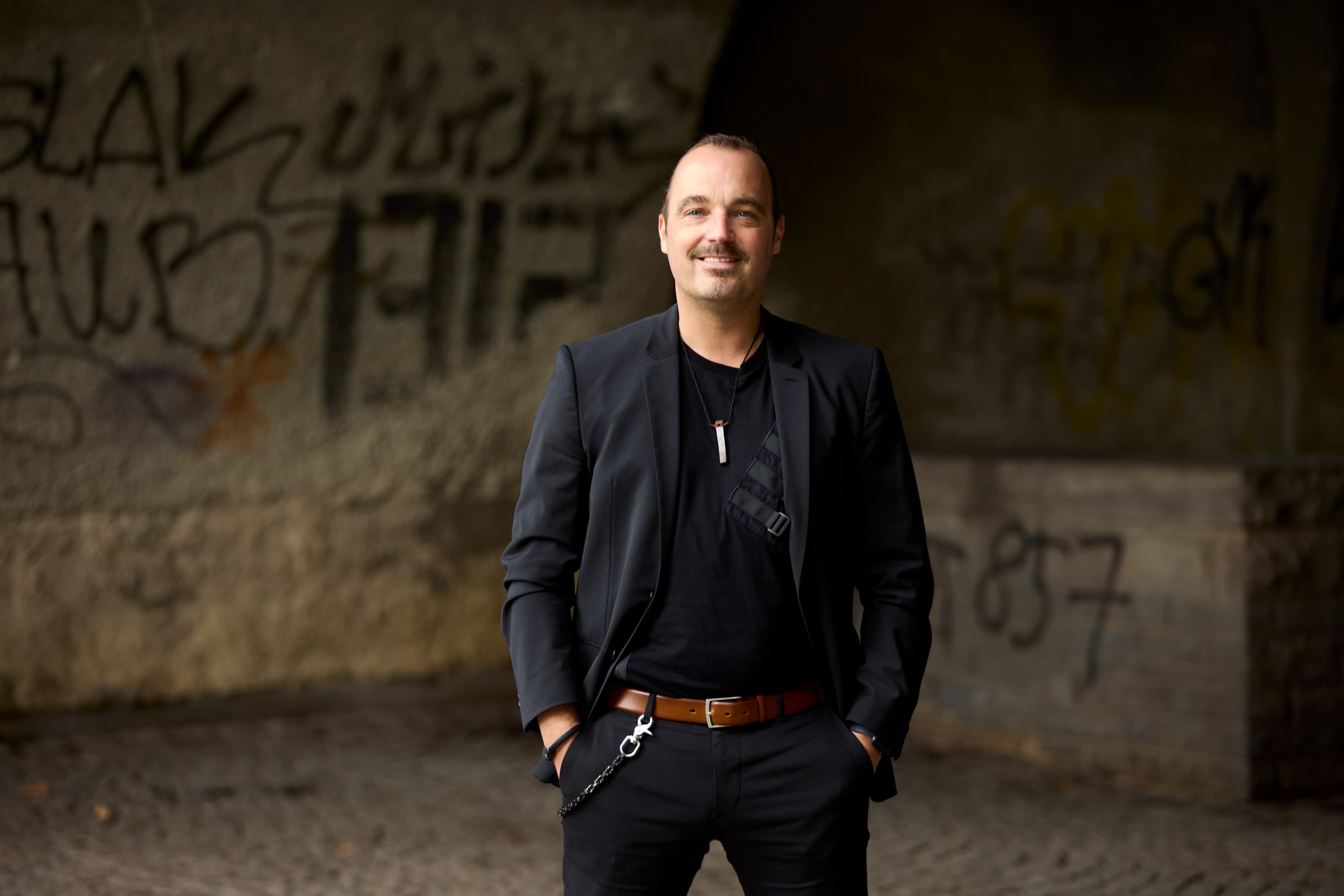 Markus Wessel vor einer urbanen Betonwand, Blick in die Kamera
