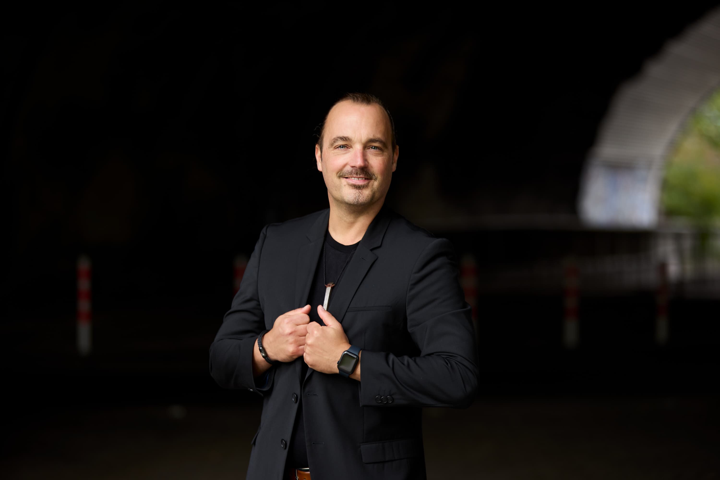 Markus Wessel, Gründer von Küchenherde, im schwarzen Blazer vor einem dunklen Untergrund